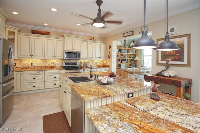 kitchen featuring ornamental molding, appliances with stainless steel finishes, cream cabinets, and a sink