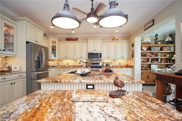 kitchen with crown molding, appliances with stainless steel finishes, a sink, and light stone countertops