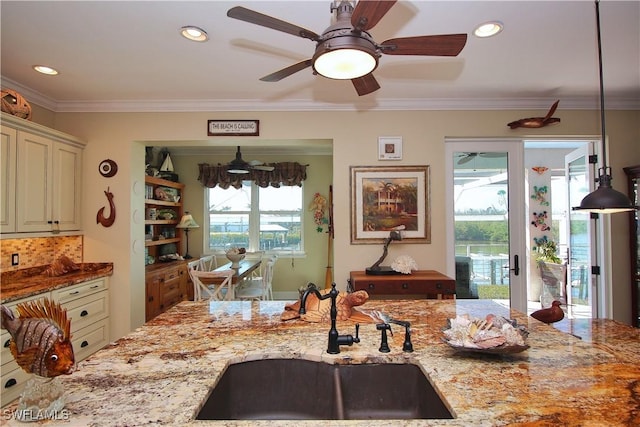 kitchen with recessed lighting, a sink, light stone countertops, tasteful backsplash, and crown molding