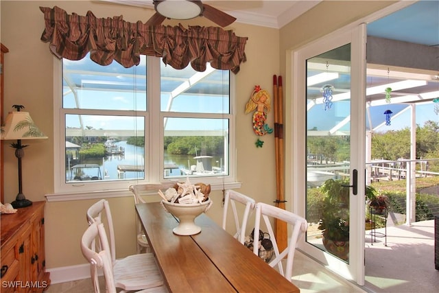 dining space with ornamental molding, a water view, and a ceiling fan