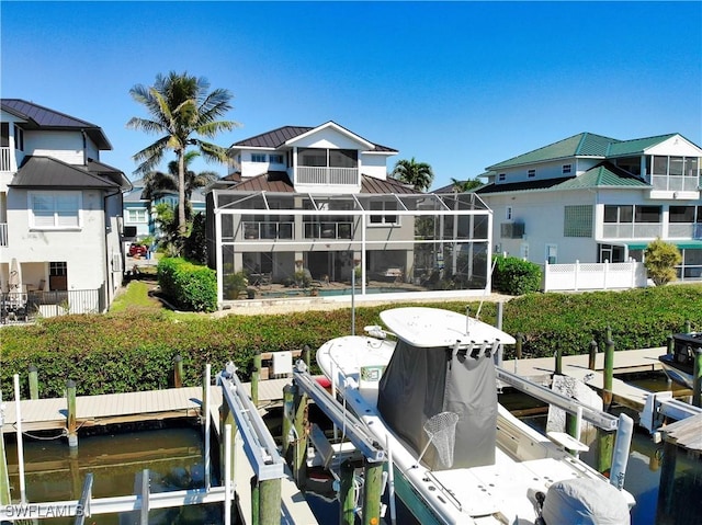 dock area with a water view, boat lift, and a lanai