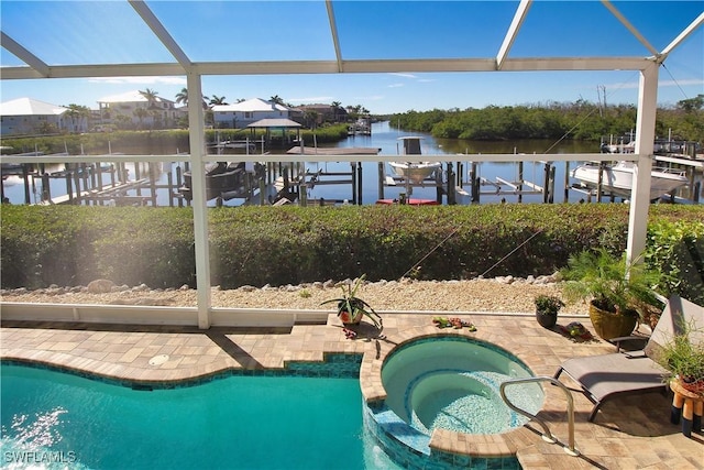 view of swimming pool featuring a water view, a patio area, a pool with connected hot tub, and a lanai