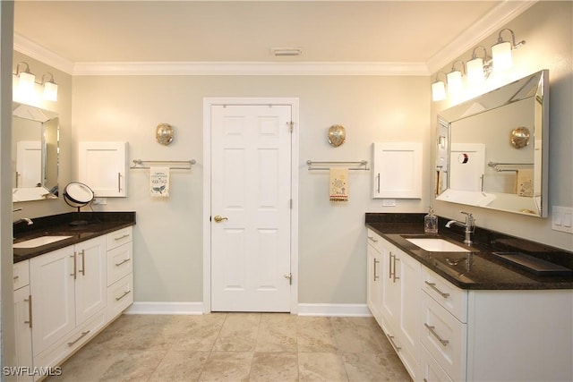 bathroom with baseboards, ornamental molding, and a sink