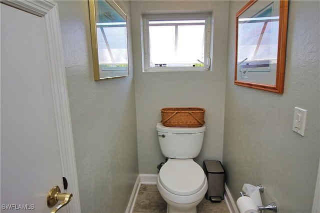 bathroom with toilet and baseboards