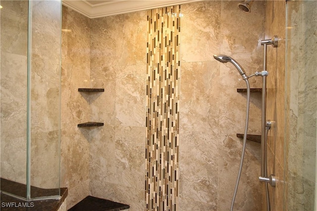 interior details with a stall shower and crown molding