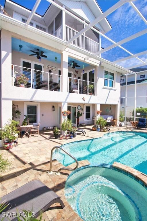 view of swimming pool featuring a lanai, a patio area, a pool with connected hot tub, and ceiling fan