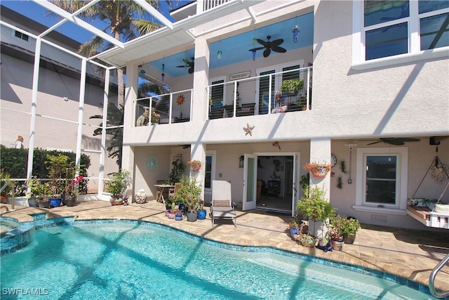 view of pool featuring a lanai, a patio area, ceiling fan, and a pool with connected hot tub