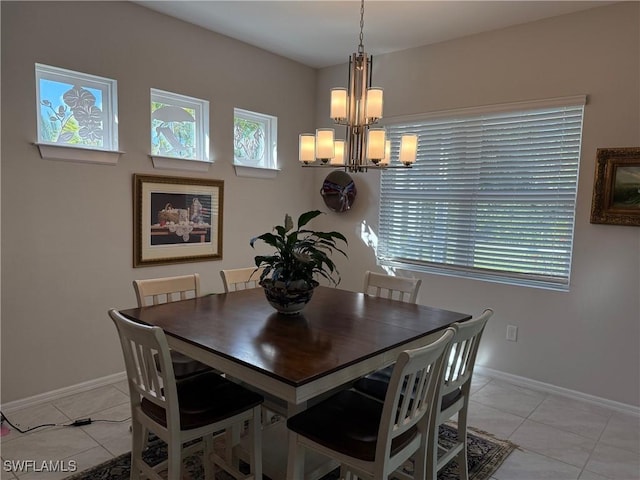 dining space with a wealth of natural light, baseboards, an inviting chandelier, and light tile patterned flooring