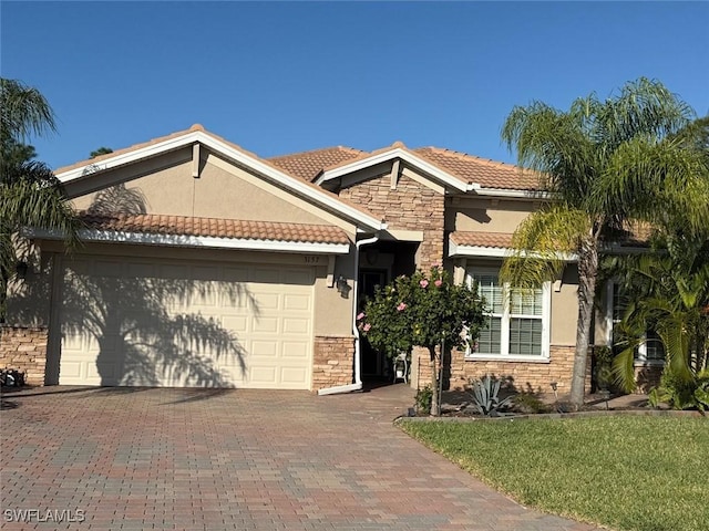 view of front of house featuring stucco siding, stone siding, a garage, and driveway