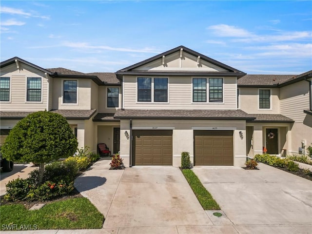 townhome / multi-family property featuring a garage, concrete driveway, roof with shingles, and stucco siding