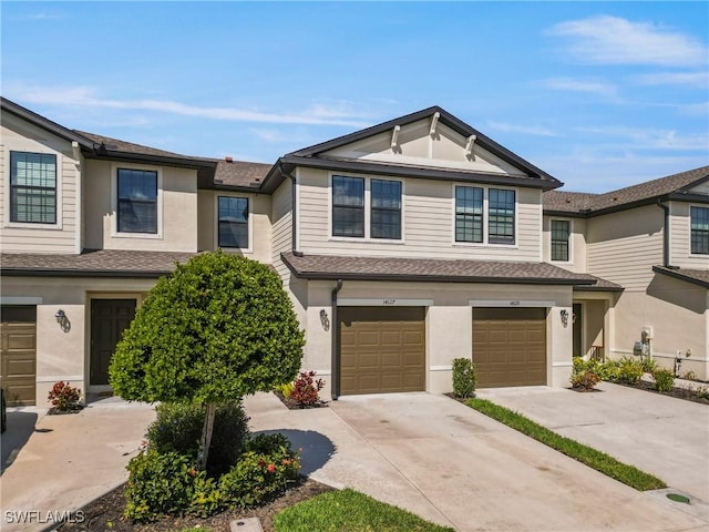 view of property with a garage, driveway, a shingled roof, and stucco siding