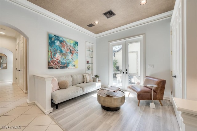 living room with visible vents, arched walkways, crown molding, and french doors