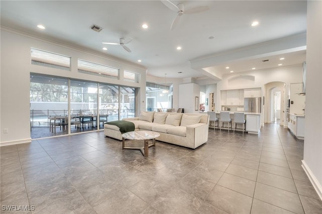 living area featuring baseboards, visible vents, a ceiling fan, crown molding, and recessed lighting