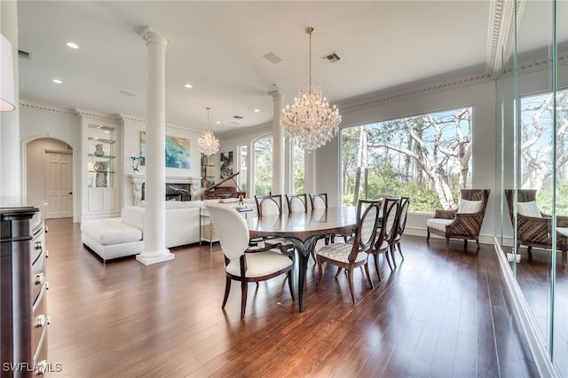 dining room with visible vents, a fireplace, dark wood-style floors, and decorative columns