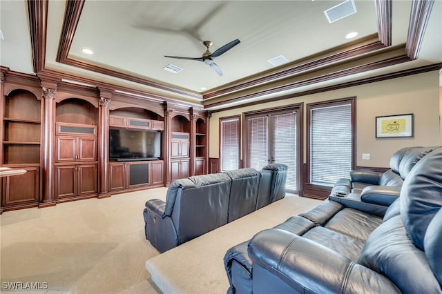 cinema room featuring a ceiling fan, a raised ceiling, visible vents, and light colored carpet