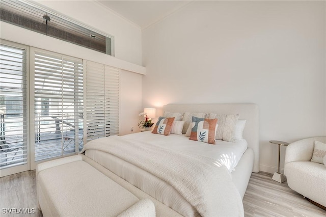 bedroom with access to outside, crown molding, and wood finished floors