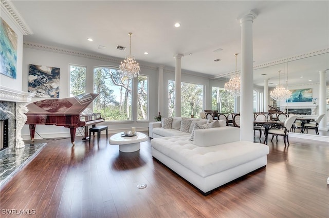 living room featuring decorative columns, a high end fireplace, wood finished floors, an inviting chandelier, and recessed lighting