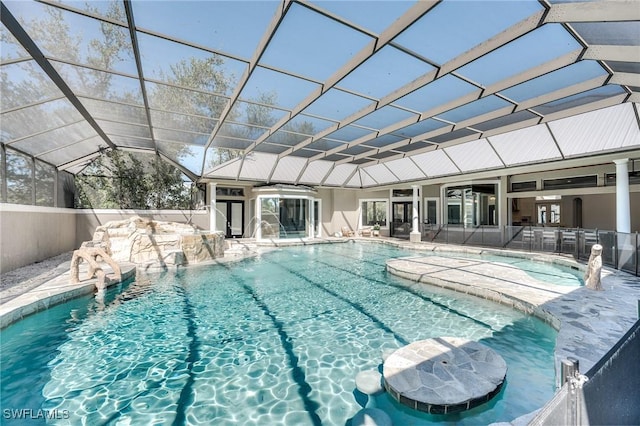 outdoor pool with glass enclosure and a patio area