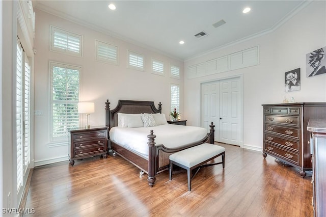 bedroom with visible vents, wood finished floors, crown molding, a closet, and recessed lighting