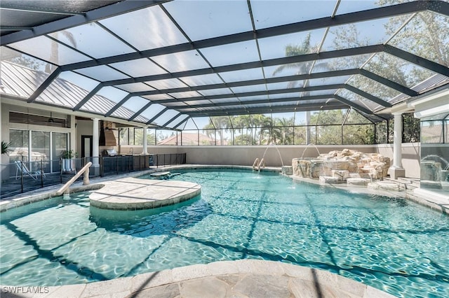 pool featuring glass enclosure, a ceiling fan, and a patio