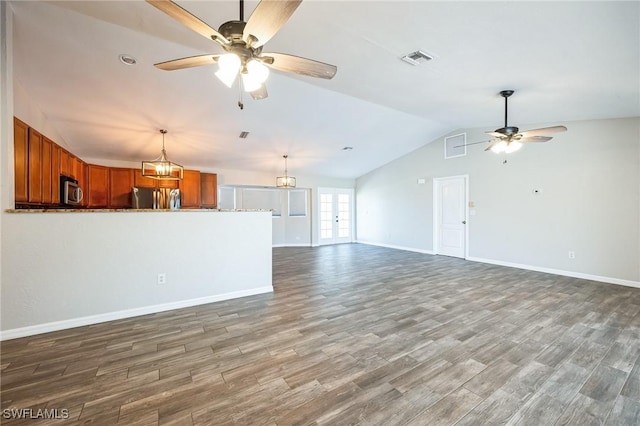 unfurnished living room featuring lofted ceiling, visible vents, wood finished floors, baseboards, and ceiling fan with notable chandelier