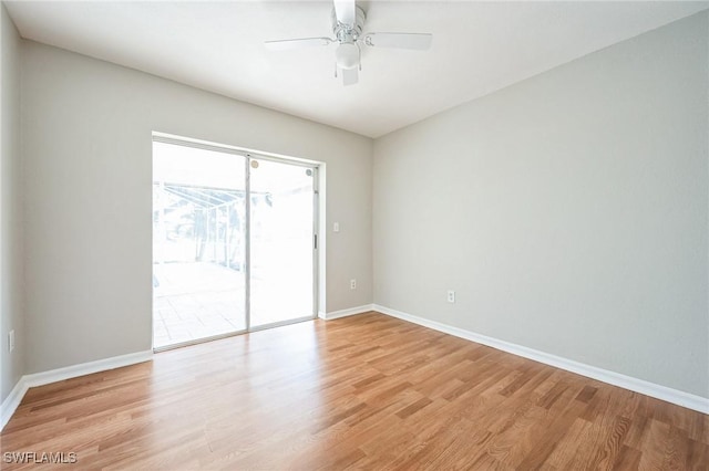 empty room with light wood finished floors, a ceiling fan, and baseboards