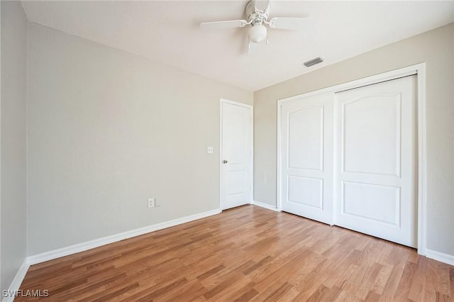 unfurnished bedroom featuring ceiling fan, visible vents, baseboards, a closet, and light wood-type flooring