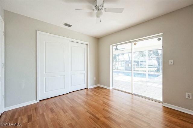 unfurnished bedroom featuring light wood-style flooring, a closet, visible vents, and access to exterior