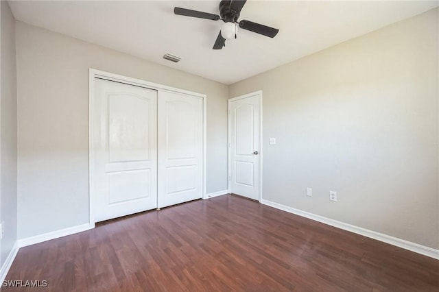 unfurnished bedroom featuring a closet, wood finished floors, visible vents, and baseboards