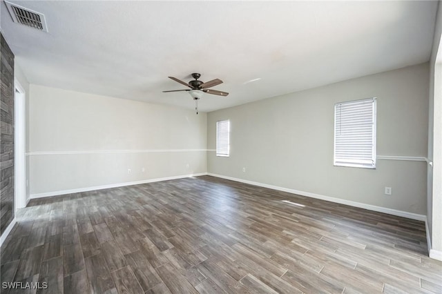 spare room with ceiling fan, wood finished floors, visible vents, and baseboards