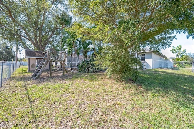 view of yard with a fenced backyard and a playground