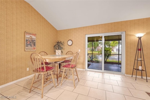 dining area featuring lofted ceiling, wallpapered walls, and baseboards