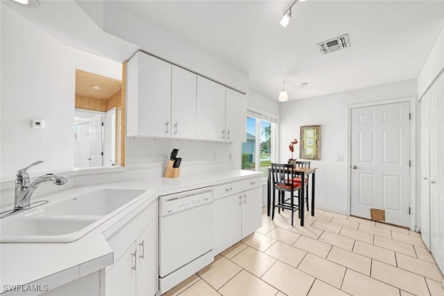 kitchen featuring light countertops, visible vents, white cabinetry, white dishwasher, and a sink