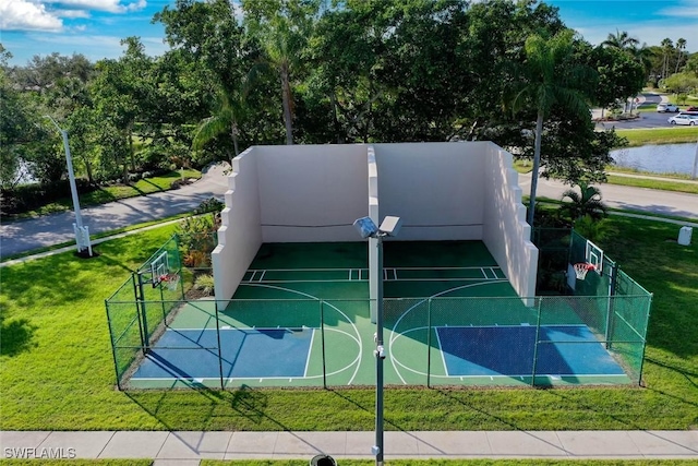 view of sport court featuring community basketball court, fence, and a lawn