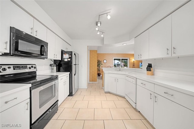 kitchen with light countertops, appliances with stainless steel finishes, white cabinets, light tile patterned flooring, and a peninsula