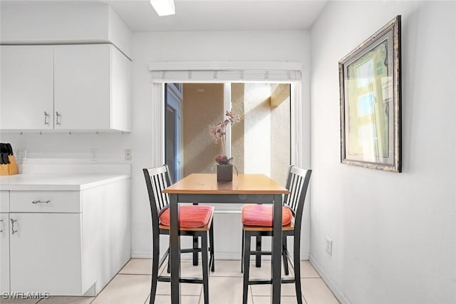 dining space with light tile patterned floors and baseboards