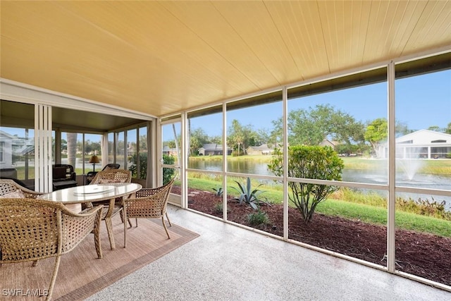 sunroom / solarium featuring a water view and wooden ceiling