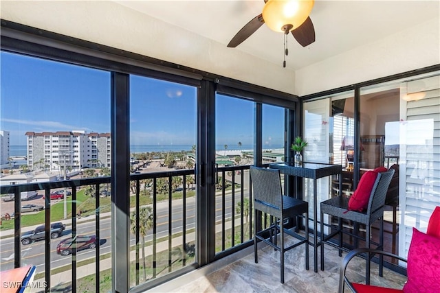 sunroom / solarium featuring a ceiling fan and a city view