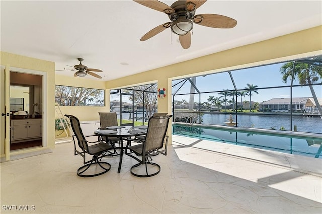 sunroom / solarium with a water view, ceiling fan, and a pool