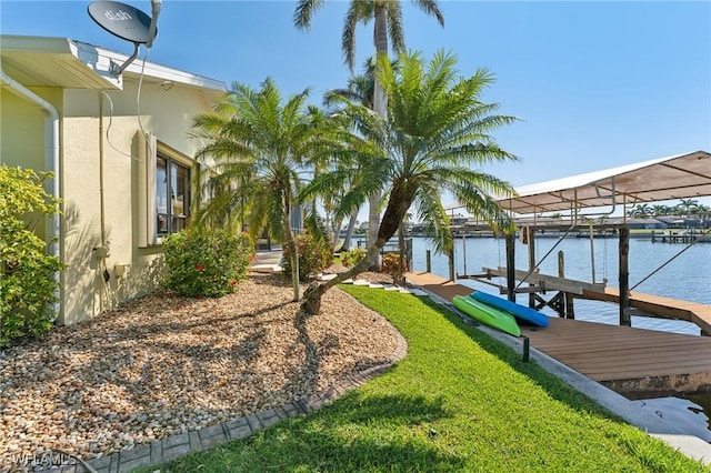 dock area with a lawn, a water view, and boat lift