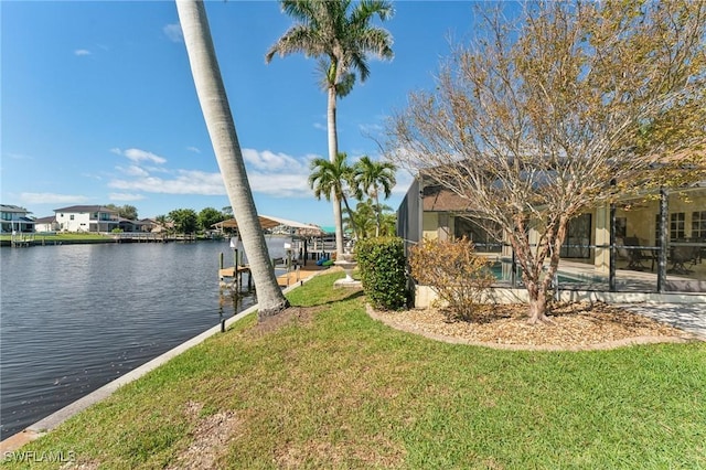 view of dock featuring glass enclosure, a patio, a water view, a lawn, and an outdoor pool