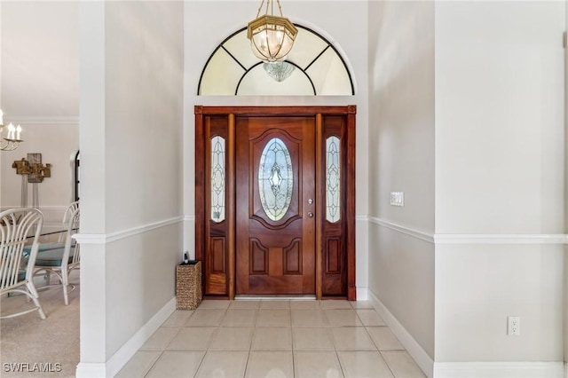 entryway with a chandelier, baseboards, and light tile patterned floors