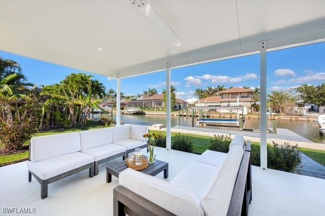 view of patio / terrace with a water view, a dock, and an outdoor living space