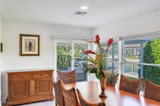 dining area with light wood-style floors and visible vents