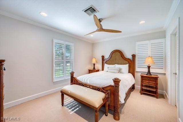 bedroom featuring light carpet, baseboards, visible vents, and crown molding