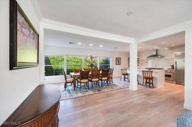 dining area featuring light wood-style flooring, ornamental molding, baseboards, and recessed lighting