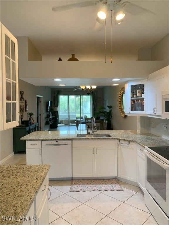 kitchen featuring white appliances, glass insert cabinets, white cabinets, and a sink