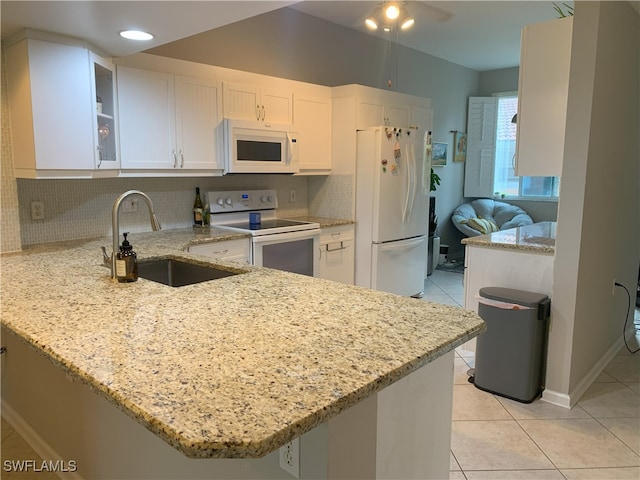 kitchen featuring a peninsula, white appliances, a sink, white cabinetry, and glass insert cabinets