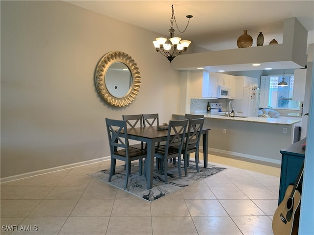 dining area with an inviting chandelier, baseboards, and light tile patterned flooring