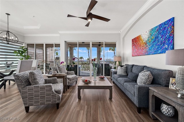 living room with ornamental molding, ceiling fan with notable chandelier, and wood finished floors